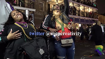 Black chick flashing one tit for the crowd during mardi gras